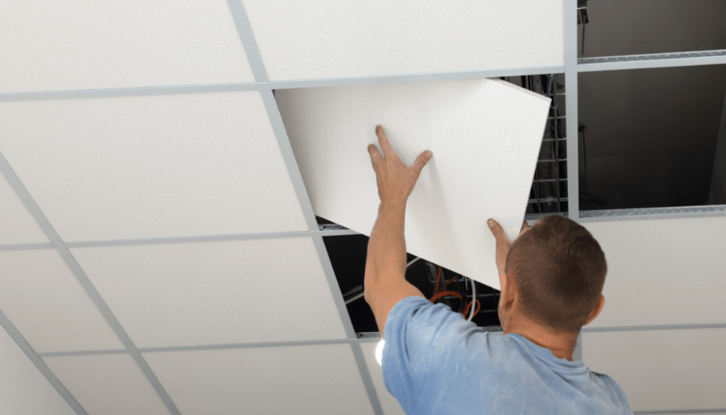 worker installing acoustic ceiling tiles